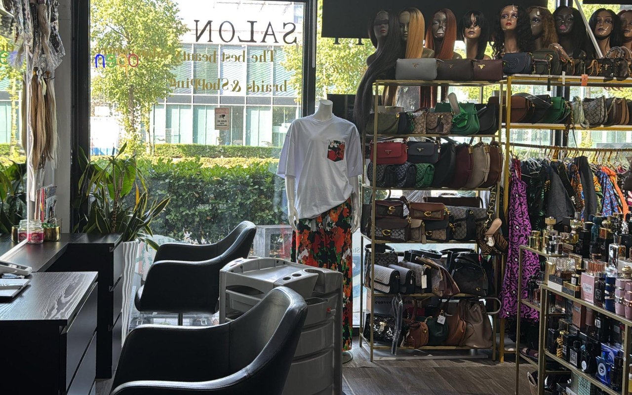Salonstoelen vooraan, daarachter de rekken met tassen en kleding