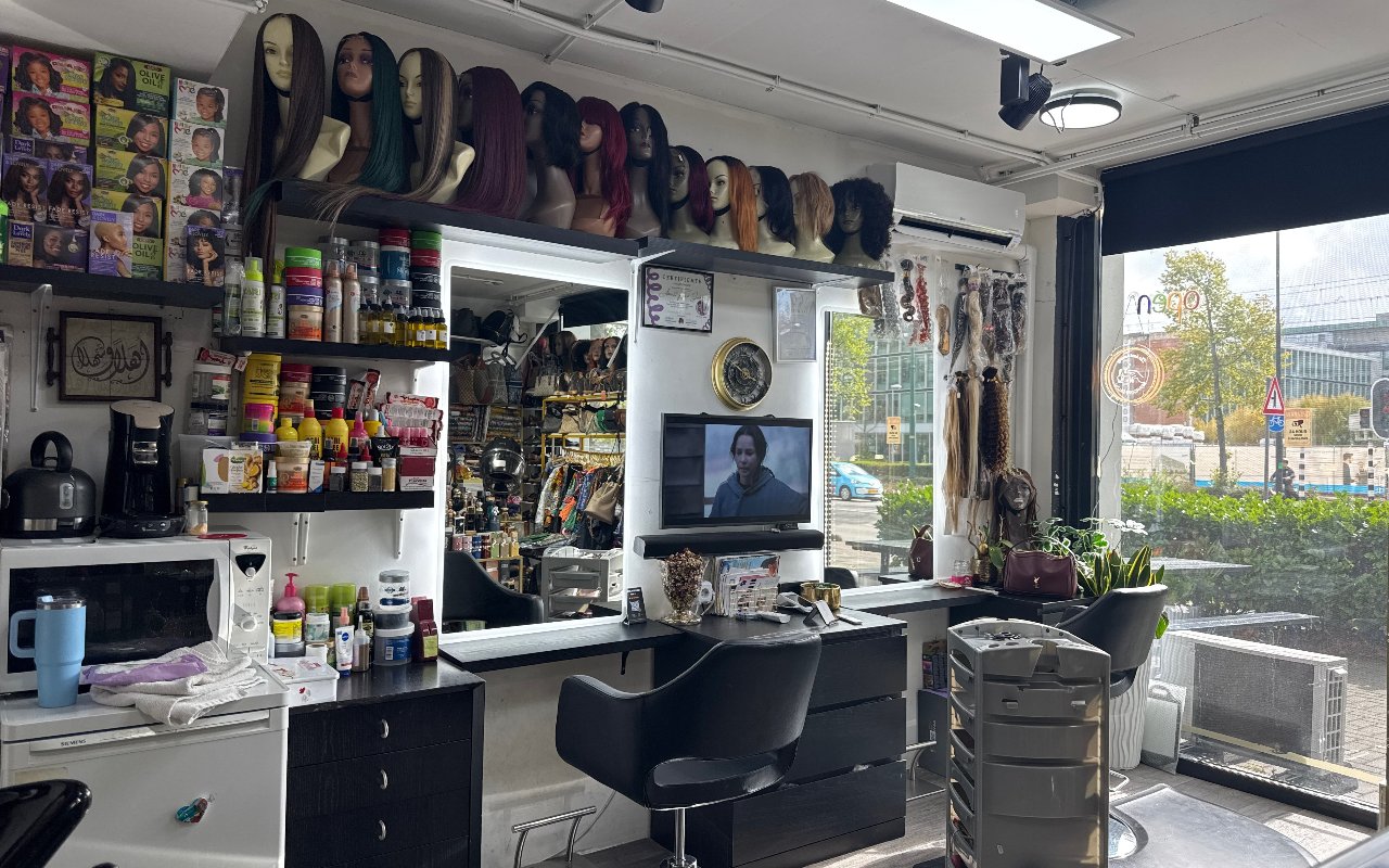 De werkbank met spiegel, en pruiken op een plank erboven