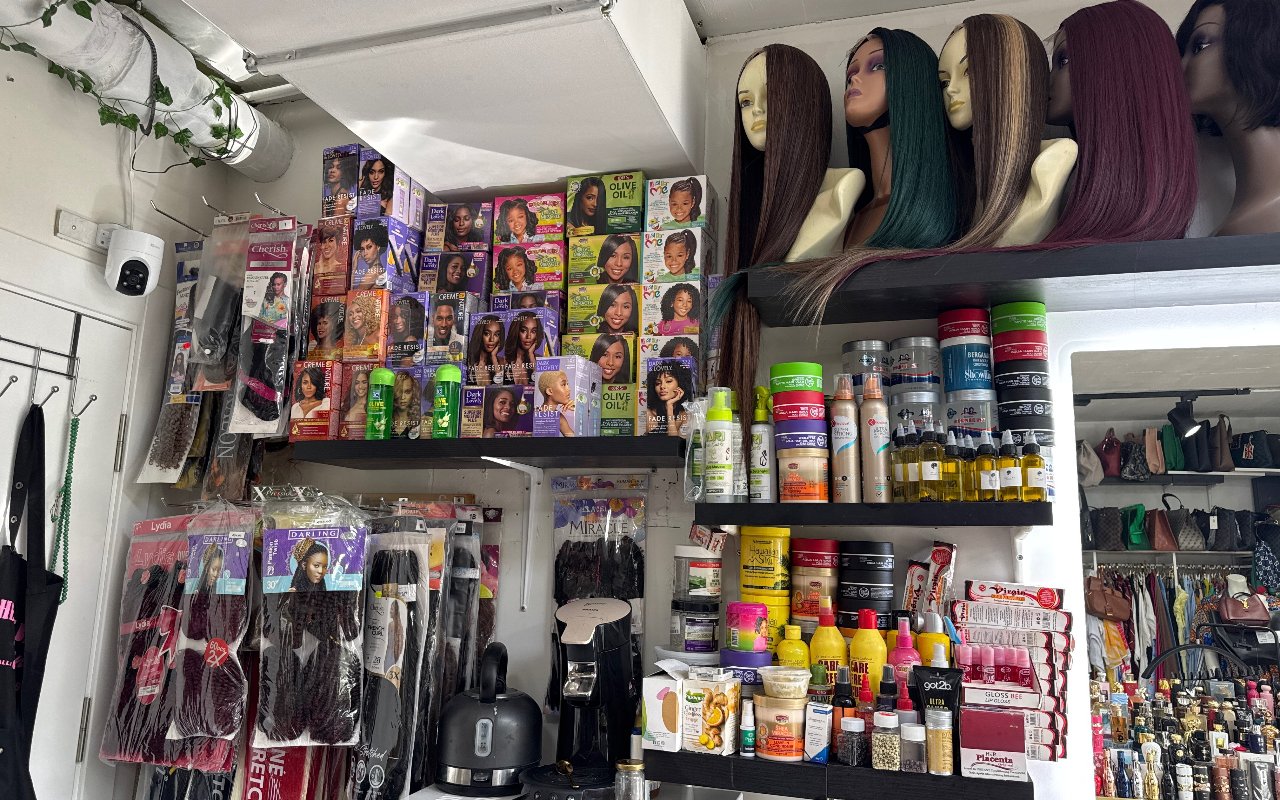 Schappen met haarproducten en een rij pruiken in verschillende kleuren